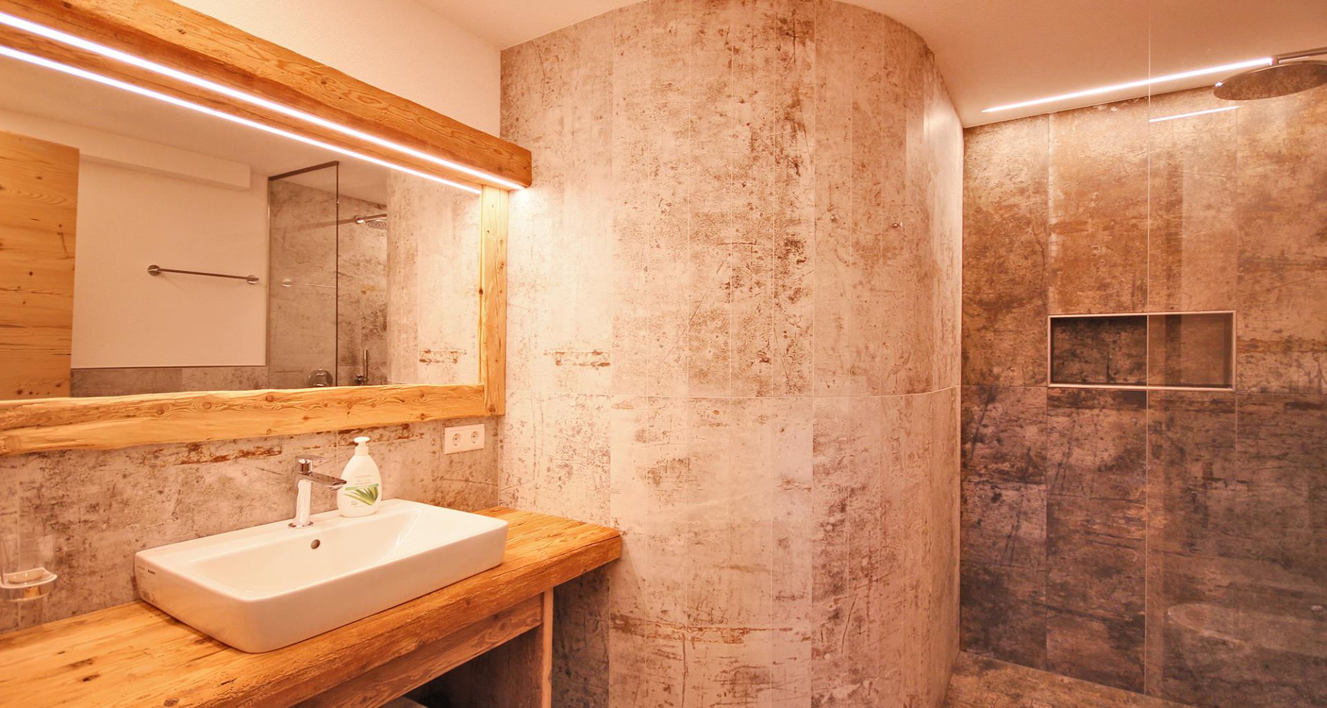 Badezimmer mit ebenerdiger Steindusche & Waschbecken